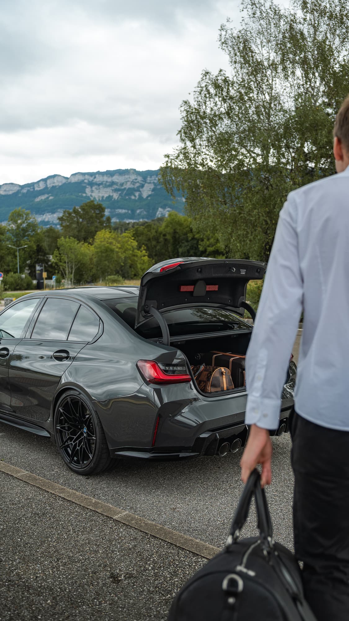 Personne avec bagages et BMW