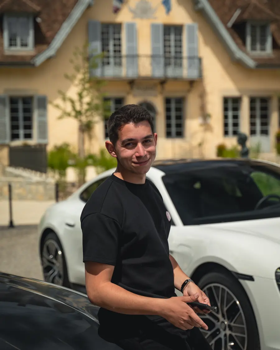 Un membre de l'équipe Corsiva près de la Porsche Taycan