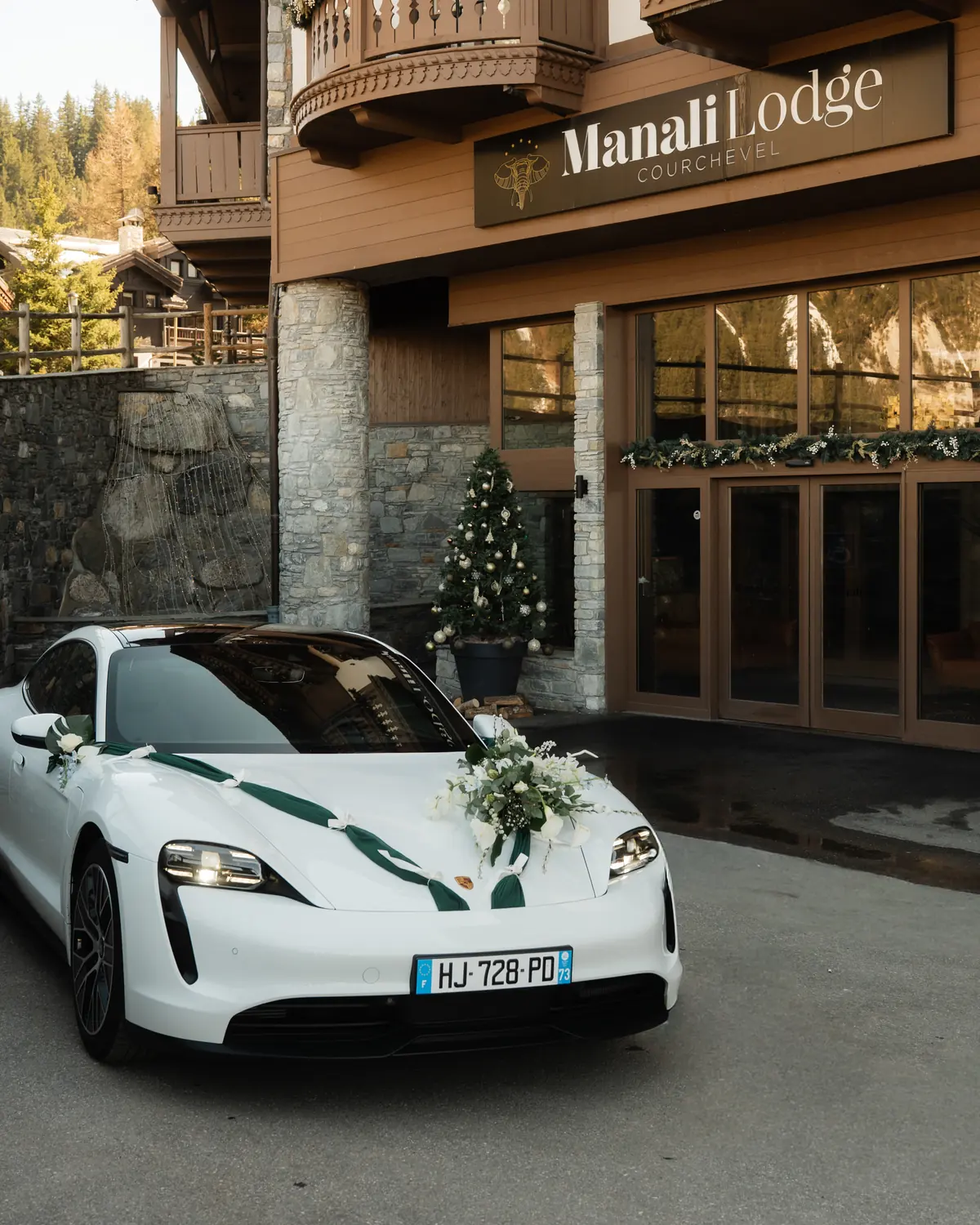 Porsche Taycan Corsiva fleurie devant le Manali Lodge, hôtel 5 étoiles de Courchevel
