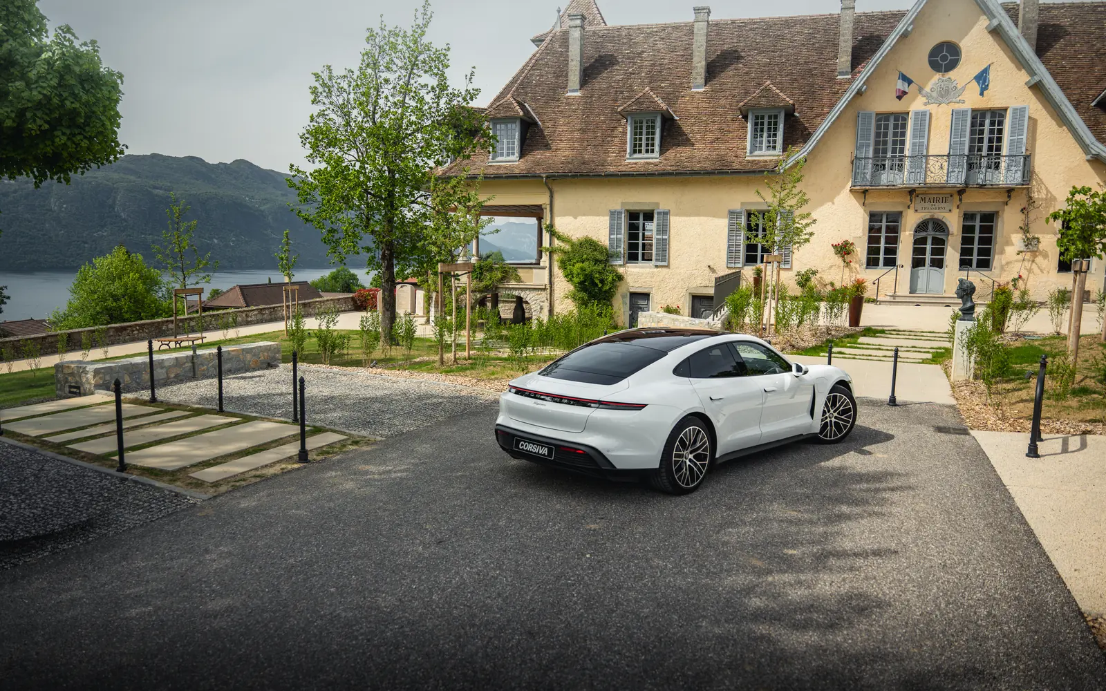 Porsche Taycan devant un château au bord du lac