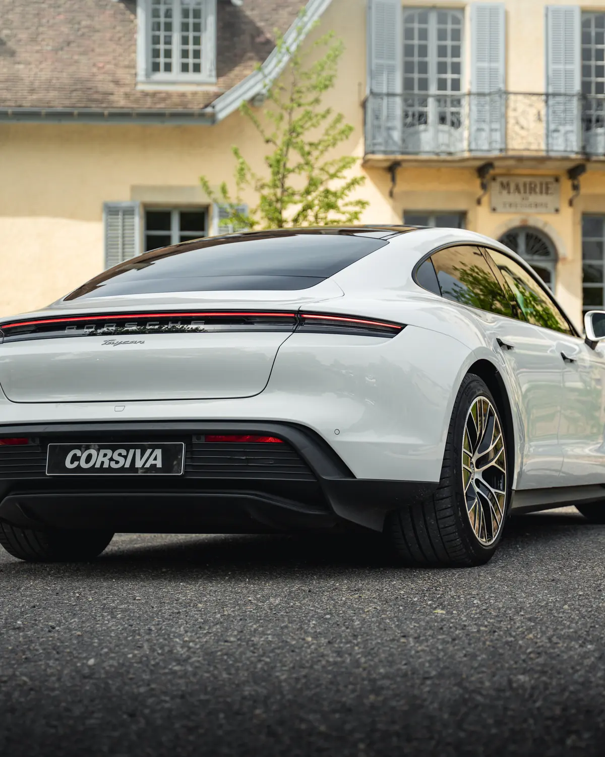 Porsche Taycan blanche Corsiva devant un château
