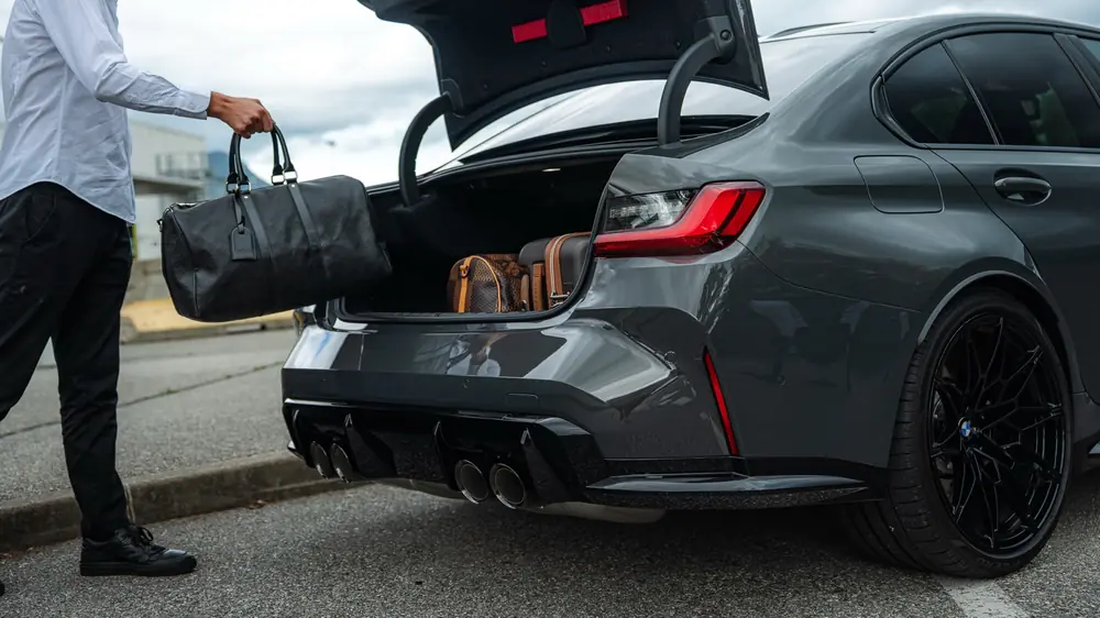 Sac de voyage dans le coffre d'une BMW M3 Compétition Corsiva