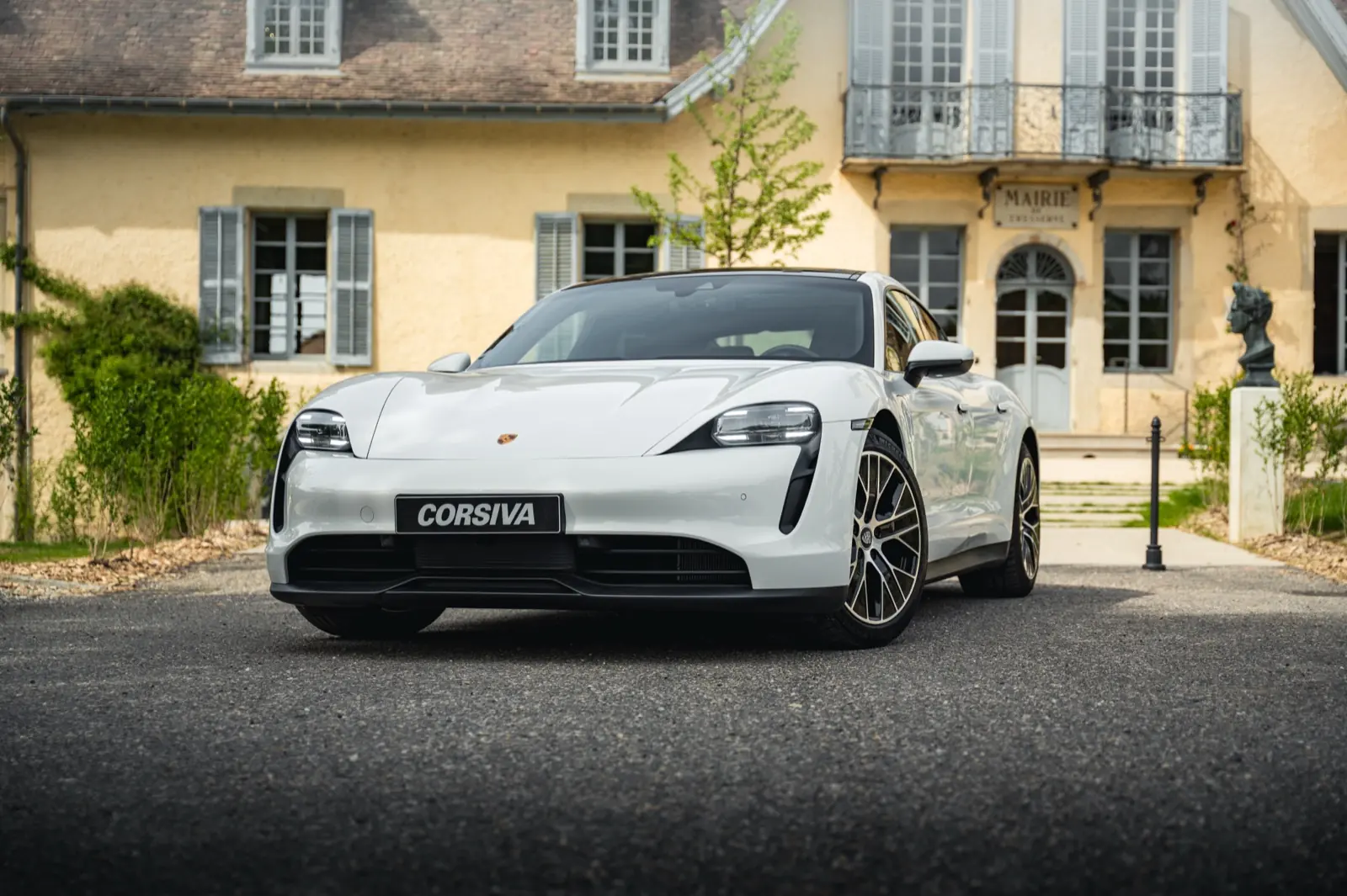 Porsche Taycan blanche Corsiva devant une demeure savoyarde