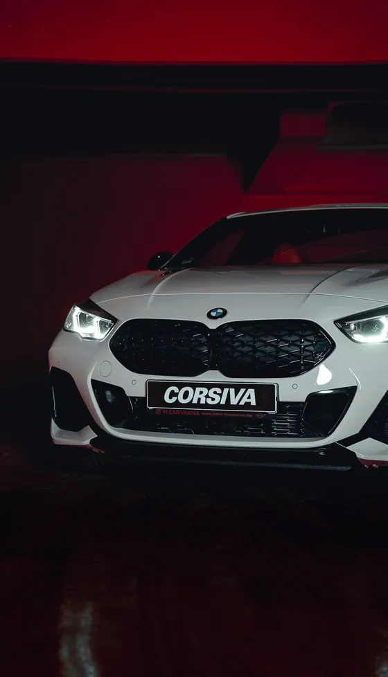 BMW M235i blanche sur fond rouge
