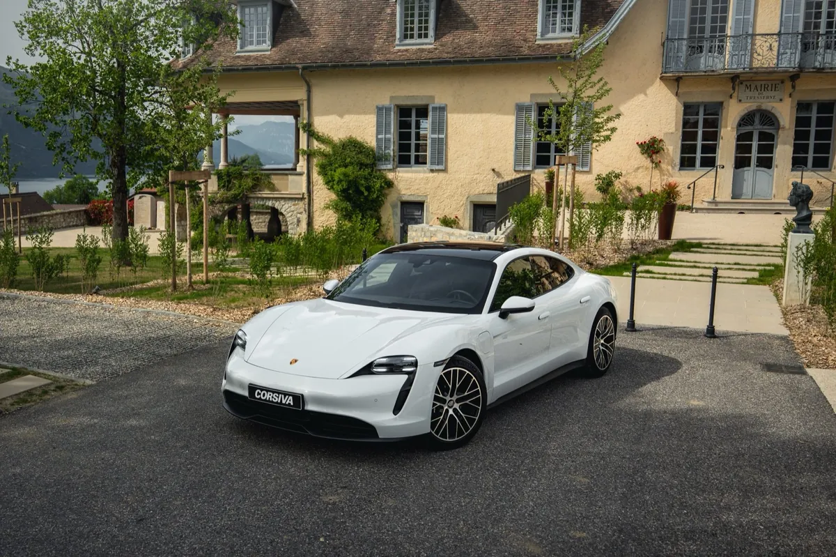 Porsche Taycan blanche de trois quarts devant un château