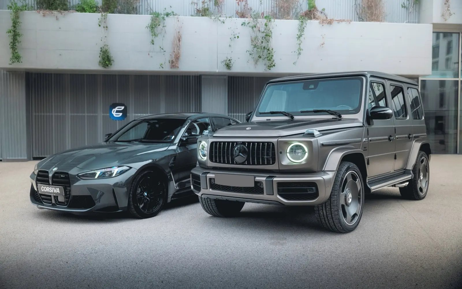 The grey Mercedes G 63 AMG 2025 and the BMW M3 Competition from the Corsiva fleet outside the Corsiva garage in Chambéry